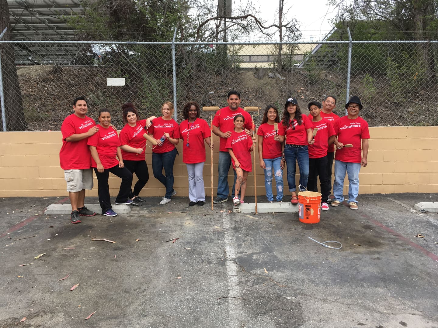 A group of people standing in front of a fence.