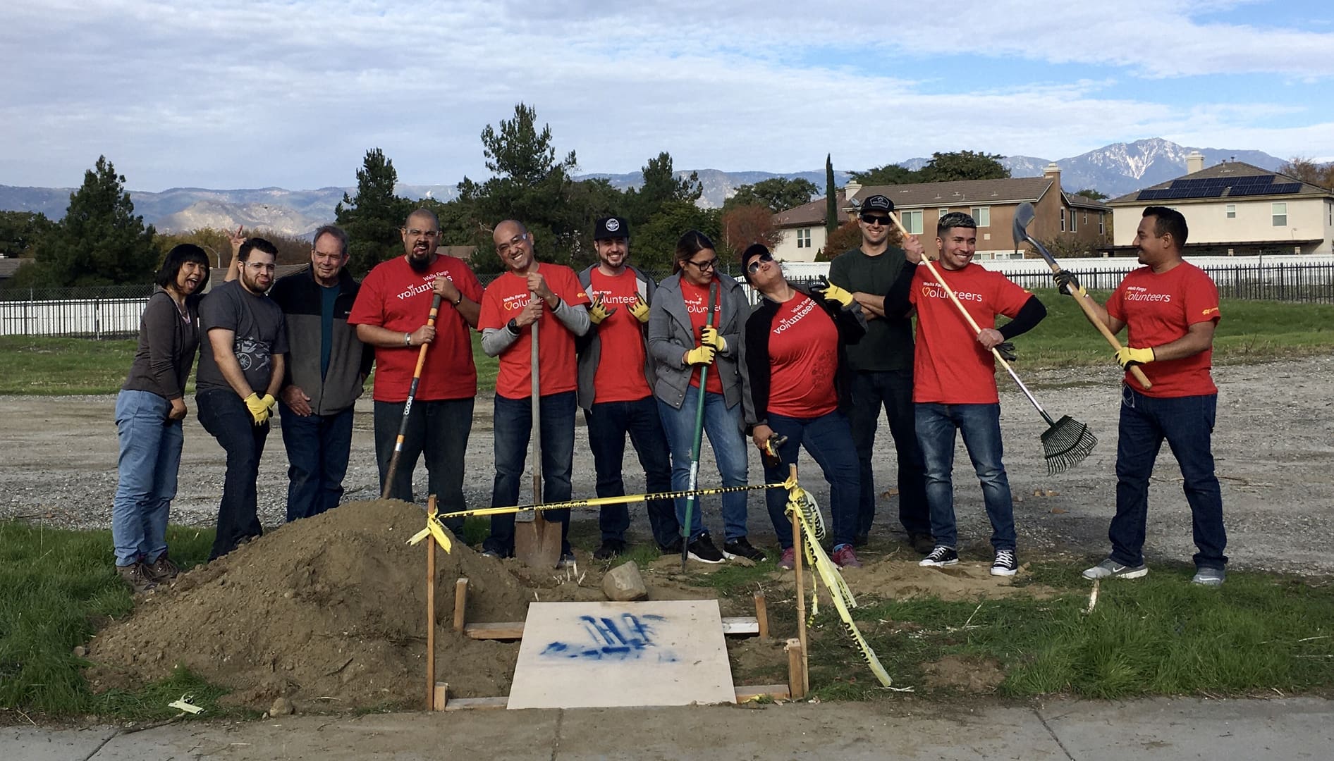 A group of people standing around a hole.