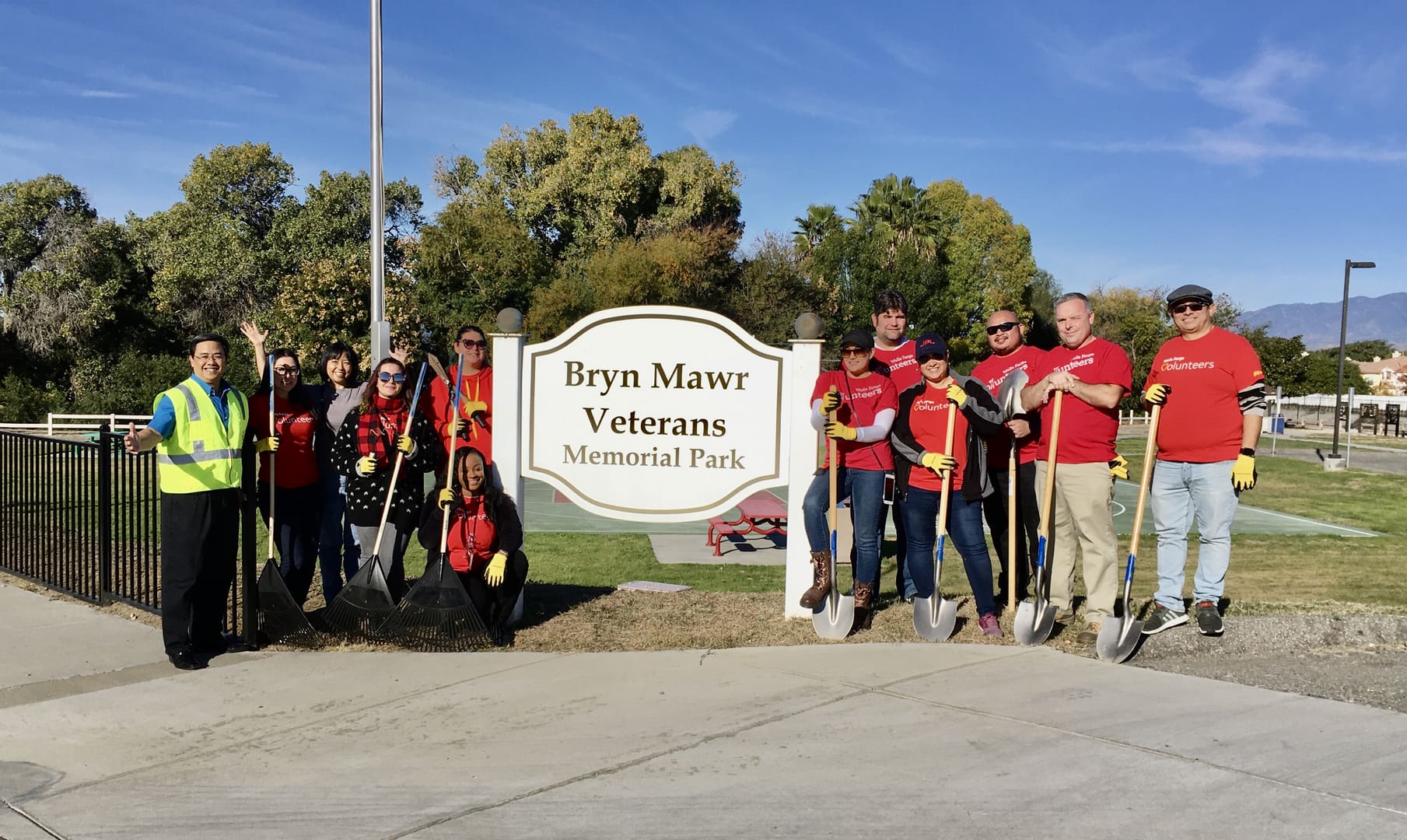 A group of people standing in front of a sign.