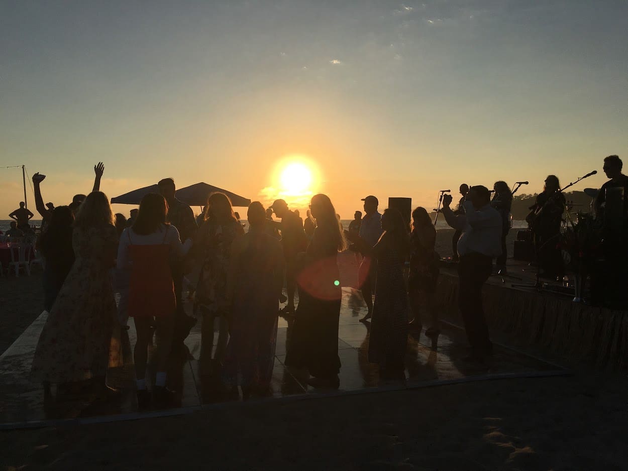 A group of people standing in front of the sun.