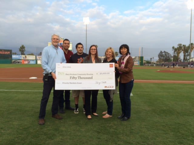 A group of people holding up a giant check.