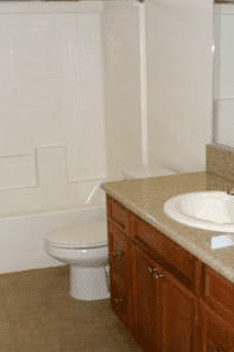 A bathroom with a toilet, sink and bathtub.