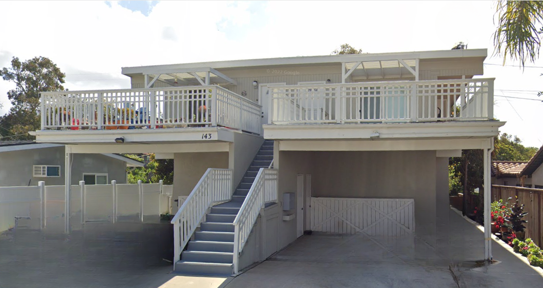 Off white four plex, tuck under car port with stairs leading to upper units.