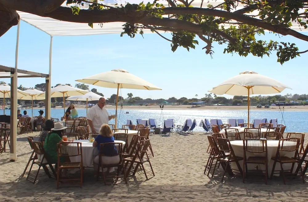 Beachside dining with umbrellas and tables.